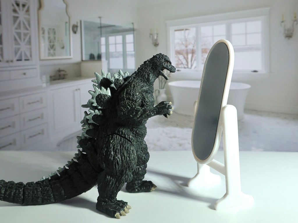 Japanese gachapon Godzilla toy looking in mirror
