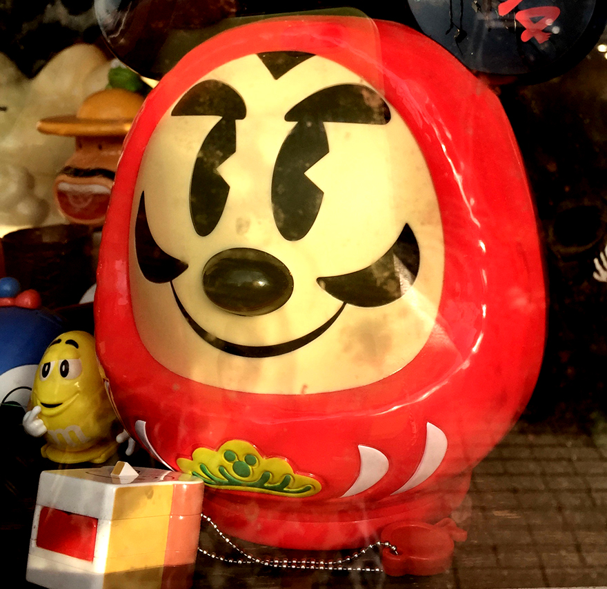 Daruma figure with creepy Micky Mouse features