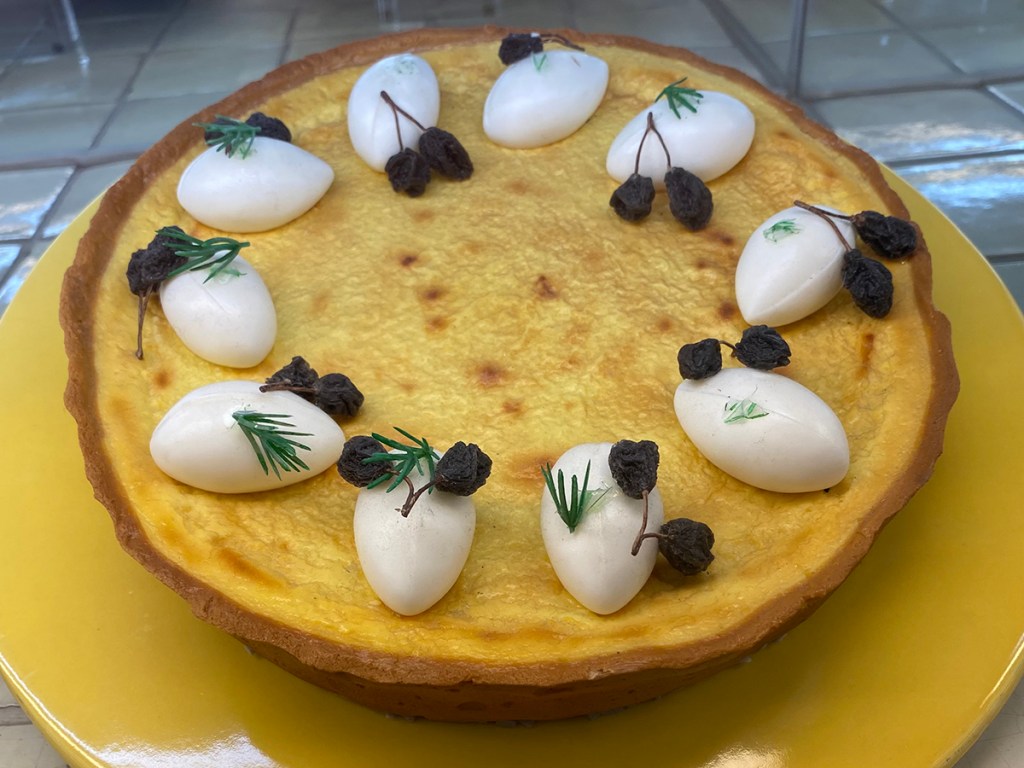 Japanese cheesecake garnished with shriveled grapes and pine needles